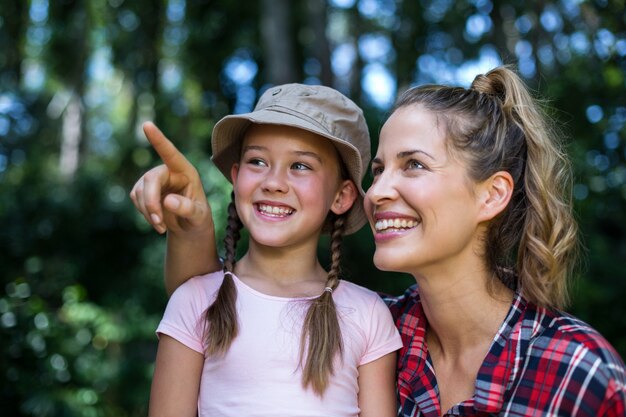 Madre felice che indica in su dalla figlia