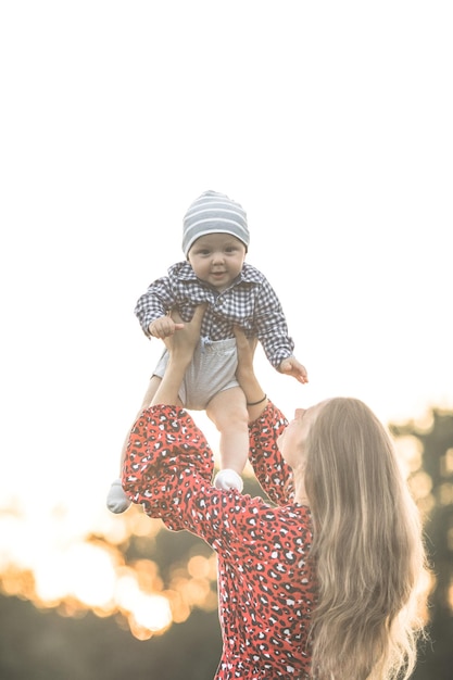 Madre felice con figlio che si gode la natura in una giornata di sole Scatto di una bella giovane mamma che gioca e abbraccia il suo simpatico figlio