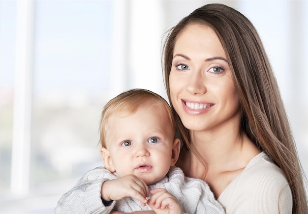 Madre felice con il bambino dolce sullo sfondo