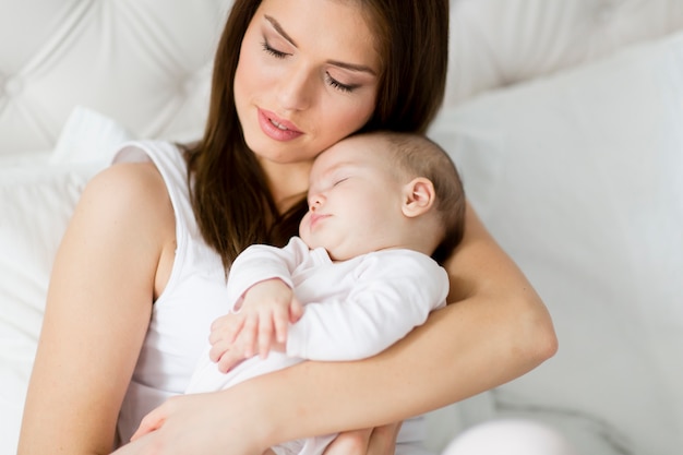 Madre felice con il bambino sul letto