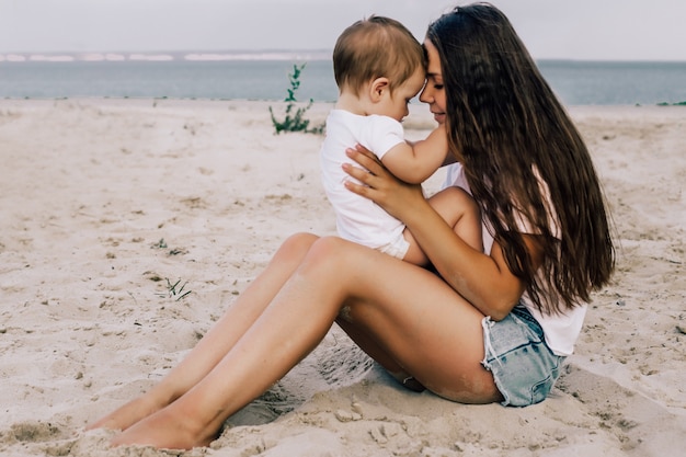 Madre felice con il suo bambino sulla spiaggia