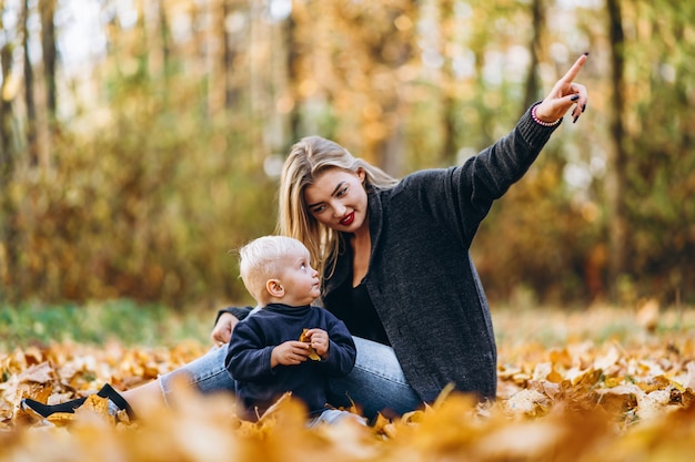 Madre felice con il suo piccolo figlio del bambino che si diverte nel parco