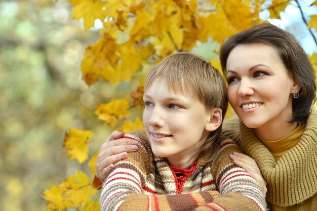 Madre felice con ragazzo nel parco autunnale