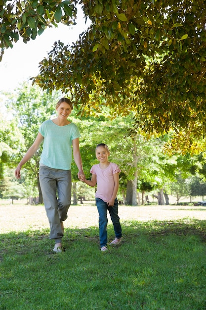 Madre felice e figlia che camminano al parco