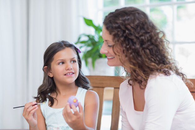 Madre felice e figlia che dipingono le uova di Pasqua