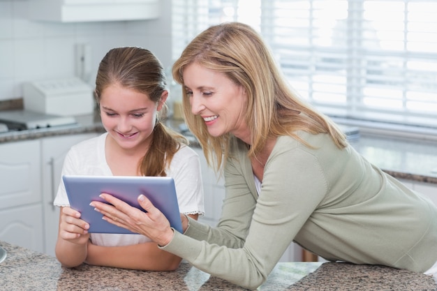 Madre felice e figlia che per mezzo insieme del pc della compressa