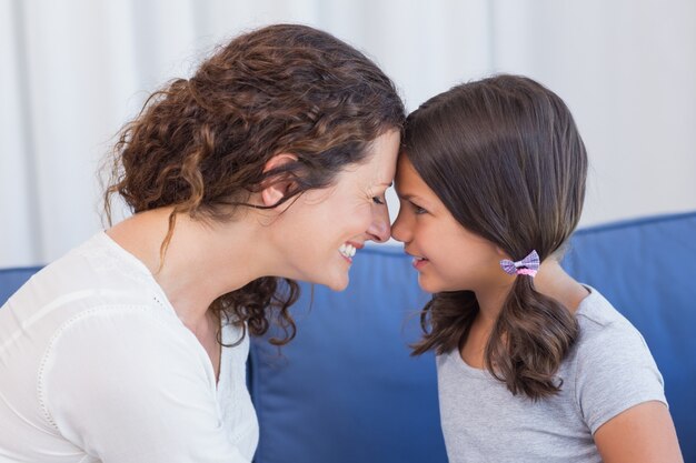 Madre felice e figlia che sorridono a vicenda