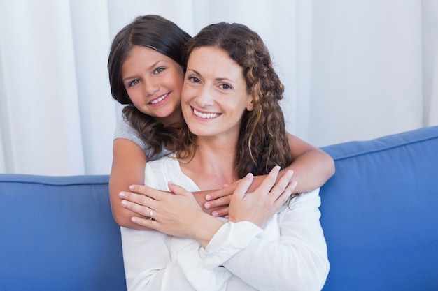 Madre felice e figlia che sorridono alla macchina fotografica