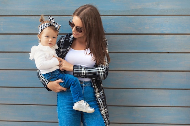 Madre felice e figlia del bambino nel look della famiglia del denim