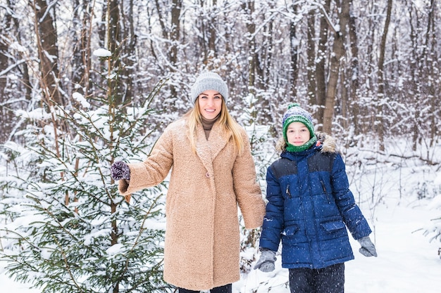 Madre felice e figlio che si divertono e giocano con la neve in inverno