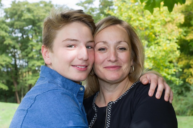 Madre felice e figlio nel ritratto all'aperto del prato di primavera