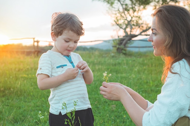 Madre felice e figlio sulla natura sul tramonto