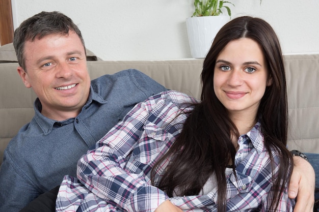 Madre felice e sua figlia carina che sorridono e posano a casa.