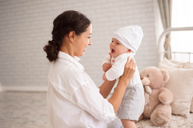 Madre, giocando con il suo bambino ragazzo sorridente.