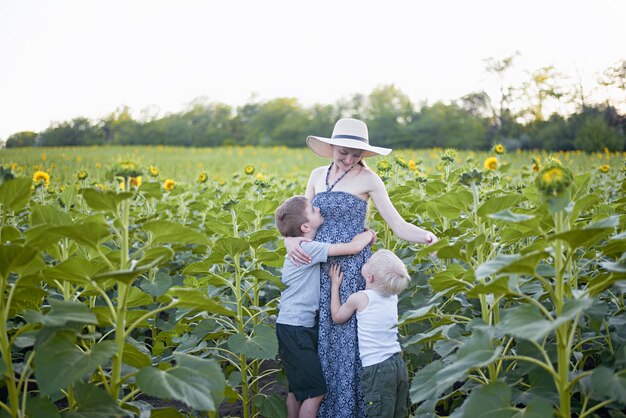 Madre incinta felice che abbraccia due piccoli figli