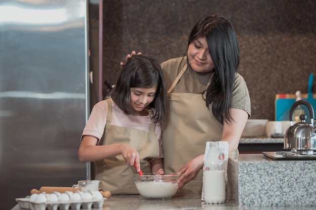 Madre messicana che insegna a sua figlia a cucinare in cucina