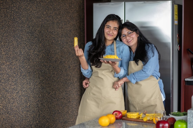 Madre messicana e figlia in cucina con una colazione all'ananas