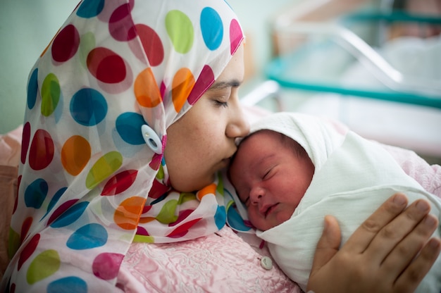 Madre musulmana araba che trasporta il bambino nel letto d&#39;ospedale subito dopo il parto