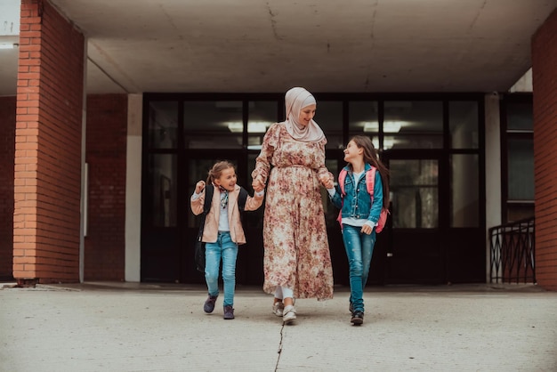 Madre musulmana Hijab che accompagna i suoi figli a scuola Messa a fuoco selettiva Foto di alta qualità