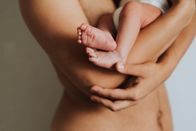 Madre nuda che tiene il suo bambino neonato