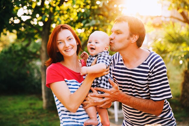 Madre padre e bambino carino bambino in abbigliamento casual alla moda sulla natura