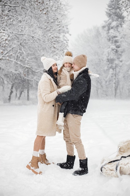 Madre padre e la loro piccola figlia che giocano all'aperto durante il giorno d'inverno