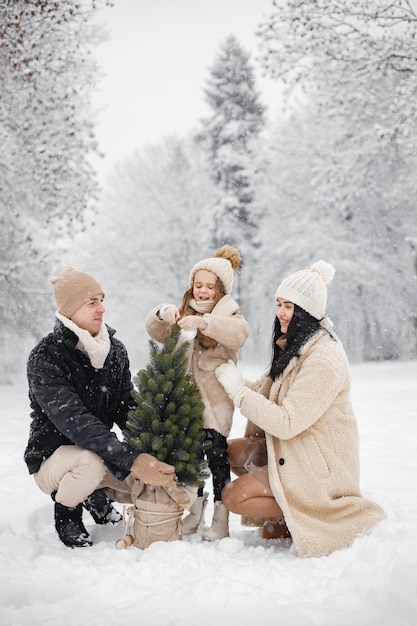 Madre padre e la loro piccola figlia che giocano all'aperto durante il giorno d'inverno