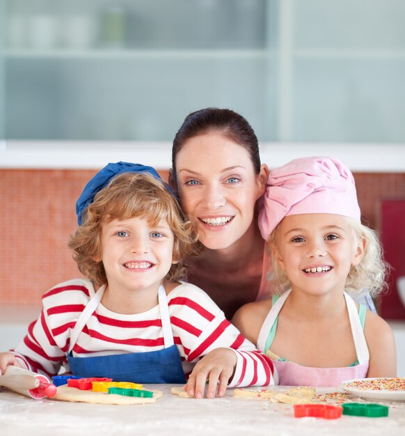 Madre radiosa che cuoce con i suoi bambini