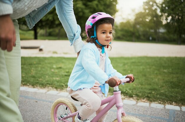 Madre ragazza e imparare con la bici in strada o al parco per un legame d'amore e felice in vacanza Mamma bambino e insegnare ciclismo e bicicletta in avventure all'aperto o nel quartiere per lo sviluppo