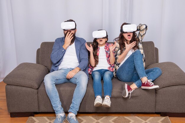 Madre scioccata, padre e figlia in occhiali per realtà virtuale, tecnologia futura.