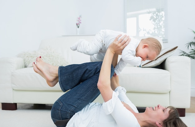 Madre sdraiata sulla schiena a giocare con un bambino