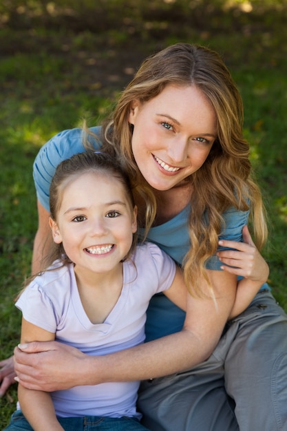 Madre sorridente che abbraccia sua figlia al parco