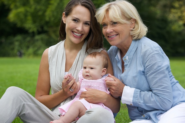 Madre sorridente con bambino e nonna all&#39;aperto