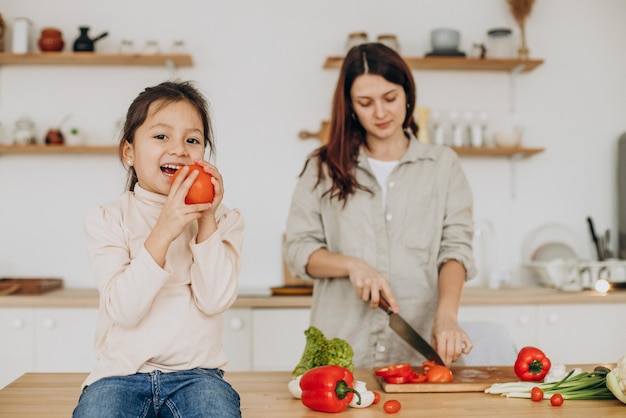 Madre una figlia che prepara l'insalata che cucina alla cucina