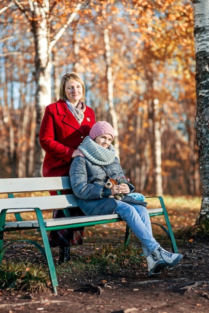 Madri e figlie camminano nel parco autunnale