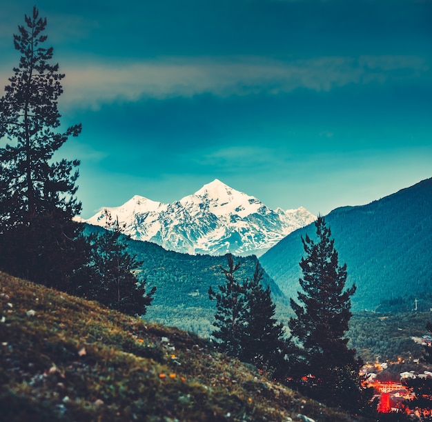 Maestosa vista dalla verde vallata alle possenti montagne innevate del Caucaso in Georgia. Splendido paesaggio sereno. Luogo turistico attraente per riposare e rilassarsi.