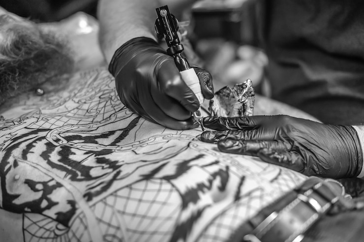 Maestro dell'arte del tatuaggio lavorando su una mitragliatrice professionale in studio