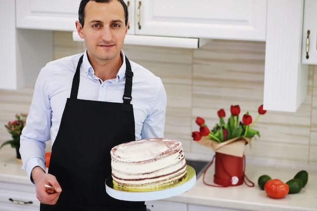 Maestro pasticcere davanti a una scrivania. Cucinare i dolci a casa. L'uomo armeno è impegnato in pasticceria.