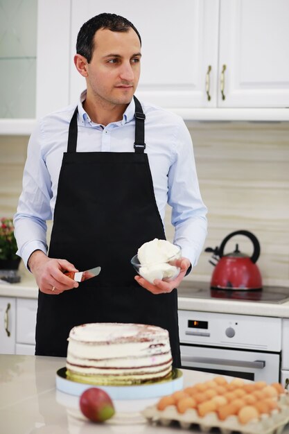 Maestro pasticcere davanti a una scrivania. Cucinare i dolci a casa. L'uomo armeno è impegnato in pasticceria.