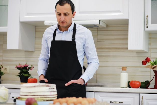 Maestro pasticcere davanti a una scrivania. Cucinare i dolci a casa. L'uomo armeno è impegnato in pasticceria.