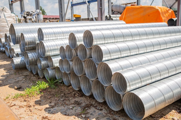 Magazzino tubi di ventilazione. Tubi in acciaio, parti per la realizzazione di condotti dell'aria per un impianto di condizionamento industriale in un magazzino. Apparecchiature per la ventilazione delle vie aeree industriali e sistemi di tubazioni.