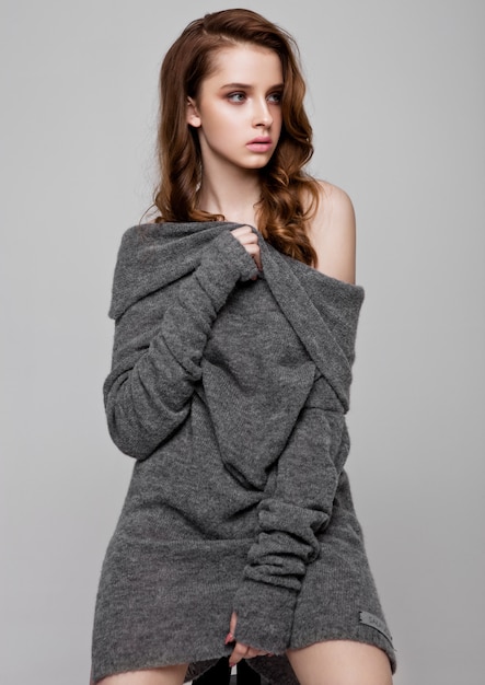 Maglione d'uso della maglieria del giovane bello modello di moda su gray