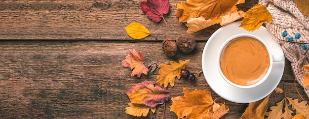 Maglione e fogliame della tazza di caffè su uno sfondo di legno Spazio per la copia della vista dall'alto