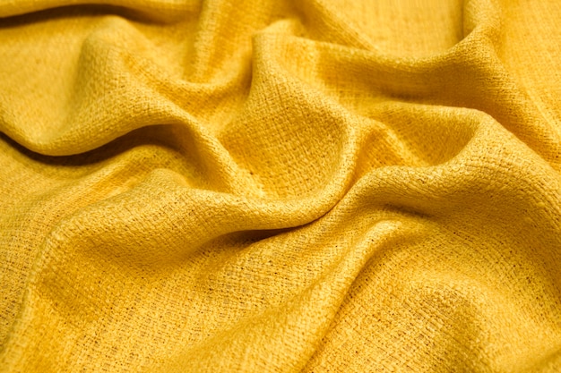 Maglione materiale giallo caldo tessuto texture su sfondo sfocato