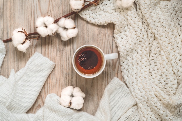 maglioni caldi e tazza di tè. Accogliente natura morta in tonalità calde. Concetto di autunno inverno.