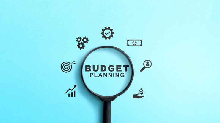 Magnifica che mostra il testo della pianificazione di bilancio con diverse icone finanziarie su uno sfondo colorato Concetto di pianificazione di budget