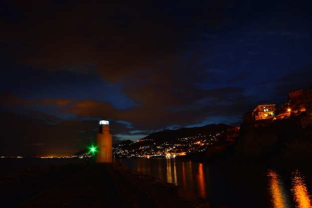 Magnifica veduta del faro di Camogli luci e colori si riflettono sul mare creando un