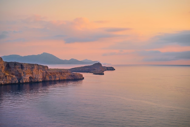 Magnifiche viste panoramiche sulle scogliere e sul calmo mare Mediterraneo illuminato dal sole del primo mattino Rodi è una destinazione famosa per le vacanze e i viaggi nelle isole greche