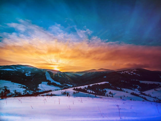 Magnifico tramonto nel paesaggio delle montagne d'inverno Ucraina dei Carpazi