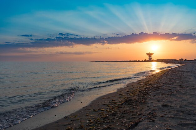 Magnifico tramonto sullo sfondo del mare e dell'antenna spaziale